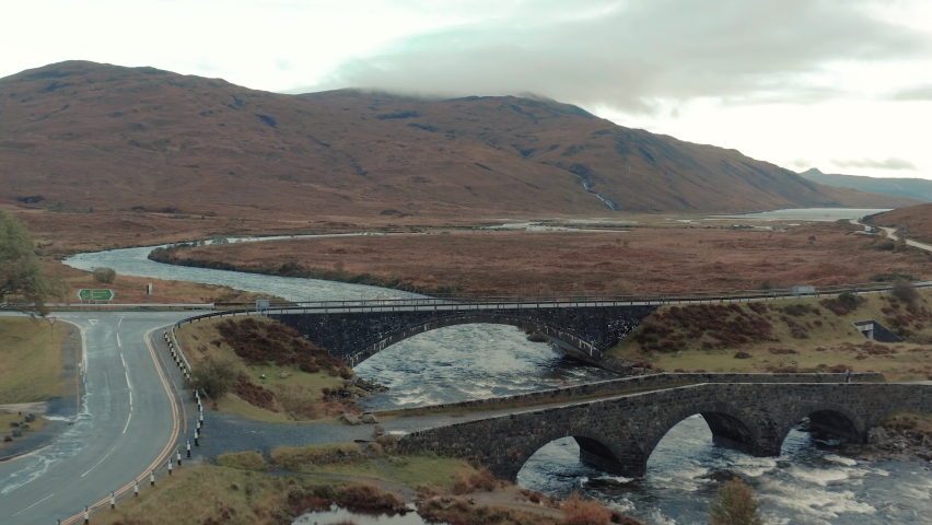 Ben Nevis mountain range surrounded by clouds at sunrise - aerial footage 4k