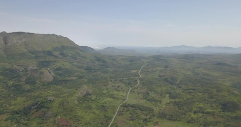 Aerial drone footage of a tropical landscape, with forest and mountains Kumbira forest reserve, small village and huge geologic rock elements, on Conda, Sumbe, Angola...