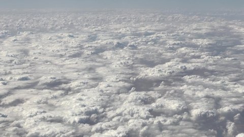 Blue sky with clouds. View over the clouds. Cloud and blue sky from the airplane windows. An aerial scenic view of cumulus. Fluffy. Beautiful white sky of fluffy clouds.