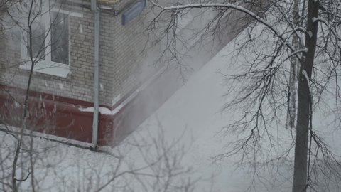 Panorama of snow removal from the roof of a four-story building
