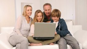 Family on sofa with laptop computer 