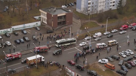 Minsk, Belarus - November 23 2021: Trolleybus hit pedestrian in city. Rescuers are trying to unblock person from public transport. Policeman blows his whistle. Passers-by look at accident. Top view.