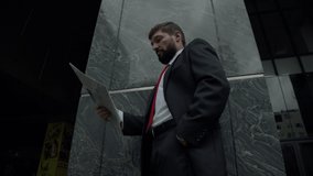 A serious middle-aged businessman in luxurious clothes in the financial district of a metropolis uses reads the news press from the newspaper near the business building. - Powered by Shutterstock - Get 15% off with code: PIKWIZARD15