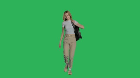 Happy young female model walking with backpack on a Green Screen, Chroma Key. 4k UHD front view isolated video.