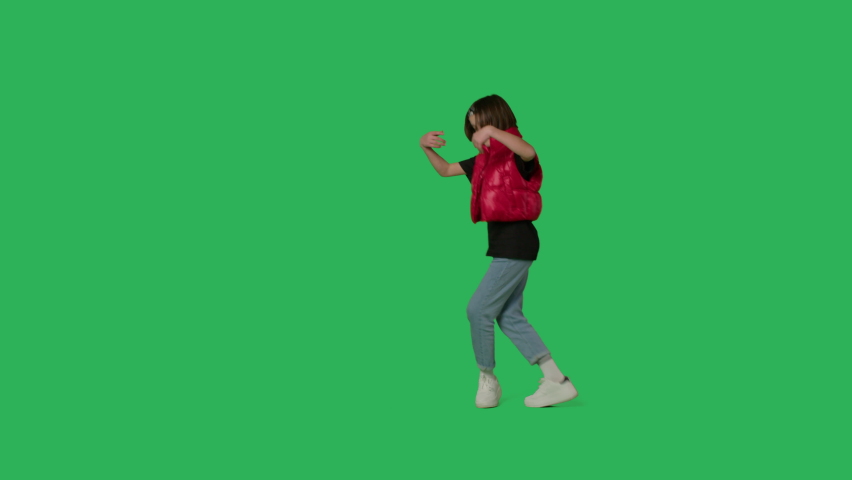 Young beautiful girl dancing hip hop, dancehall, street dance over green screen background. Happy smiling child having fun on Chroma Key. 4k uhd video footage