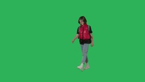 Teen girl with backpack walking on Green Screen, Chroma Key. Perspective view 4k uhd video footage