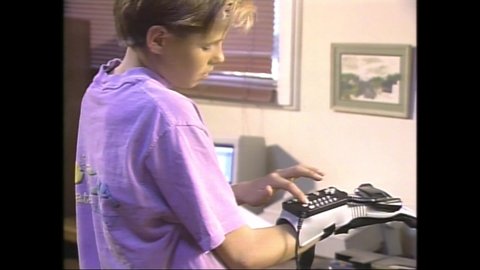 1989 Cupertino, CA. Young Man using the Nintendo Power Glove. The Virtual Reality Pioneer employed tactile sensors and haptic technology for kinaesthetic communication or 3D touch. 4K Scan of Betacam 