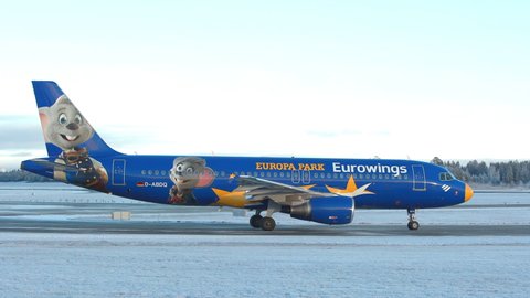 Oslo Airport Norway - December 3 2021: airplane airbus 320 eurowings taxiing europa park logo passing panning right