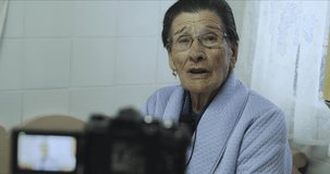 Elderly Spanish woman talking and recording on video camera. Documentary