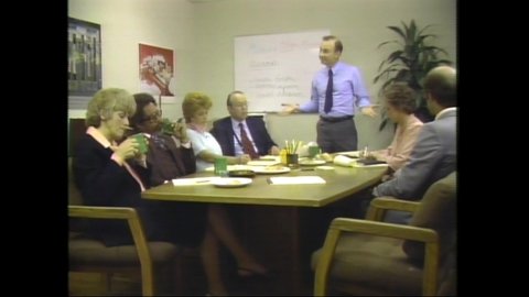 1980s Chicago, IL. In small conference room, business man leads meeting with visibly upset and frustrated colleagues. 1980s Style Fashion and Hair.  4K Scan from vintage broadcast VHS Betacam Master 