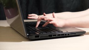 little kids fingers on black laptop keyboard, child presses buttons