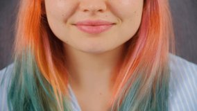 Happy young white woman with diastem and dyed hair smiling in camera. Cute Caucasian girl with colored hair posing for video with toothy smile. Royalty free 4K footage of female with friendly smile