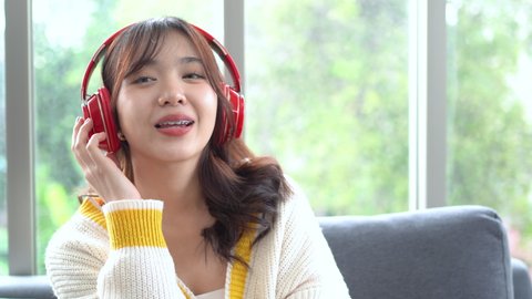 Beautiful Asian woman listening music, smelling and sipping coffee happily in the morning (Thai, Japanese, Korean or Chinese). Lifestyle at home.