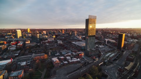 Manchester, Great Britain - circa 2021 - Establishing Aerial View Shot of Manchester, City Skyline, England United Kingdom, sun slowly comes up on the buildings