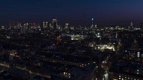 Establishing Aerial View Shot of London UK, United Kingdom, skyline at night evening, track right