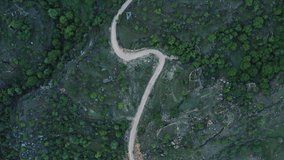 Incredible serpentine in the mountains. Aerial View of settlement in the mountains, built on a winding road. Mountain landscape, infrastructure in remote regions. 10 bit Video