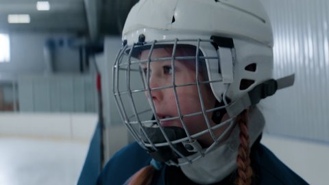 HANDHELD CU Portrait of cute little girl making her first steps on the ice as a hockey player. Shot with 2x anamorphic lens Stock Video