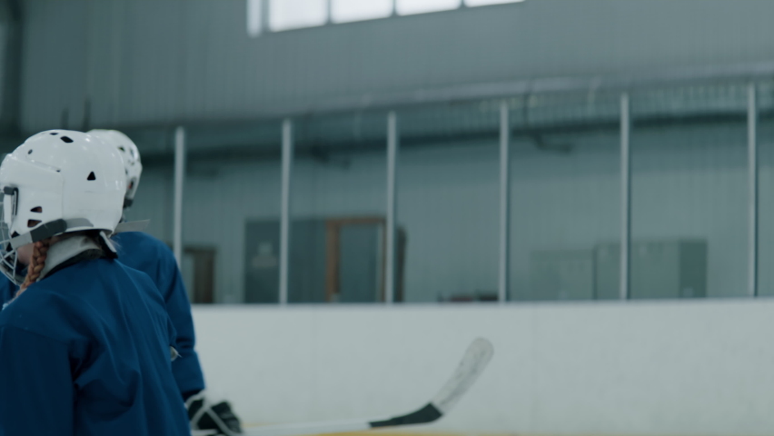 Kids cheering their teammate girl after scoring a goal during ice hockey game. Shot with 2x anamorphic lens Royalty-Free Stock Footage #1084768912