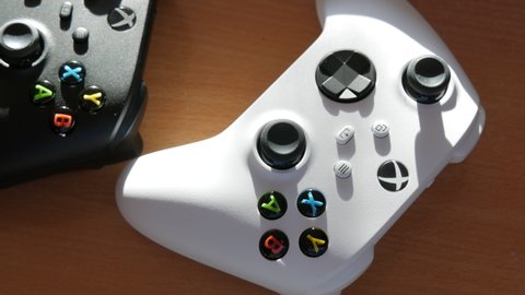 December 9, 2021 - Kehl, Germany: Two joysticks in black and white on the table in front of the game console White Microsoft Xbox Series S Game Controller, The newest wireless gamepad, joysticks for