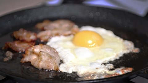 preparing breakfast. frying bacon close-up slow mo