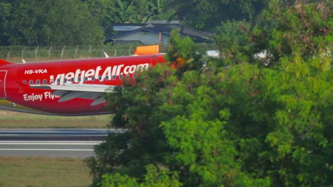 PHUKET, THAILAND - DECEMBER 1, 2018: Thai VietJet Air Airbus 320, HS-VKA arrive at Phuket Airport (HKT). Airplane at the airport, island and palm trees