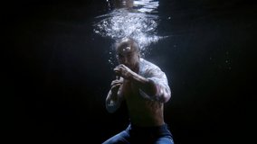 underwater shot of fighting man inside dark deepness, man is boxing inside water, slow motion shot - Powered by Shutterstock - Get 15% off with code: PIKWIZARD15