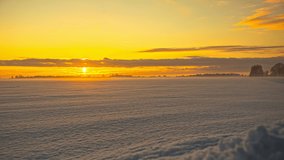 Time lapse of Majestic sunset over a snow covered landscape. Amazing light of nature, cloudscape sky and clouds moving away rolling. Colorful dark sunset clouds