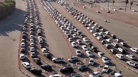 Aerial shot of 1000’s of people in cars waiting in line at a drive-through testing site to be tested for Coronavirus or to receive the vaccine. - Powered by Shutterstock - Get 15% off with code: PIKWIZARD15