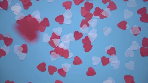 View from above. White and red hearts descend to the blue background. Background for the holiday is Valentine's Day. Congratulations on your wedding or engagement. Declaration of love.