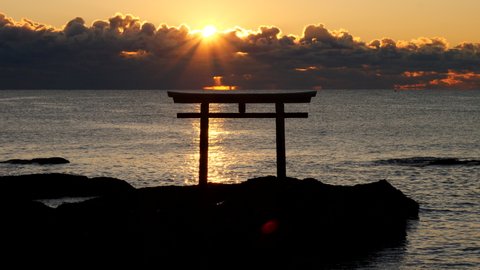 The calm sea on a winter morning and the torii gate of a Japanese shrine. Oarai town in Japan.