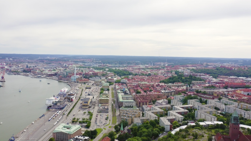 Inscription on video. Gothenburg, Sweden. Panorama of the city and the river Goeta Elv. The historical center of the city. Cloudy weather. Multicolored text appears and disappears, Aerial View