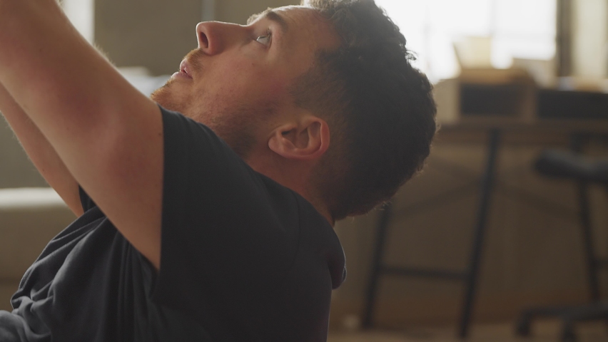 fitness, home, health and diet concept - man doing exercises for abdomen at home