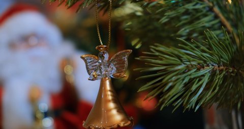 A girl hangs a Christmas tree toy in the form of an angel on the Christmas tree. The concept of holidays, Christmas, New Year. 4K video