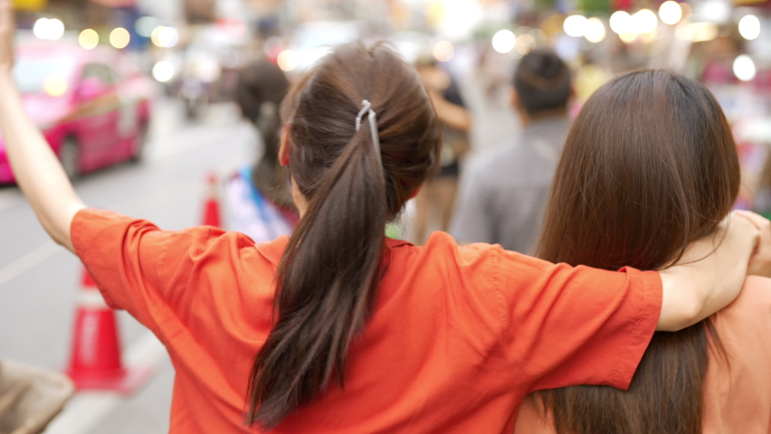 4K Asian woman friends meeting and walking together at Chinatown street night market in Bangkok city, Thailand. Female tourist enjoy outdoor lifestyle nightlife travel shopping and eating street food