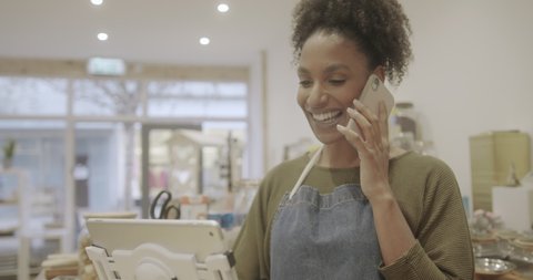 Female Speaking to Customer on Smart Phone, Small Business Owner