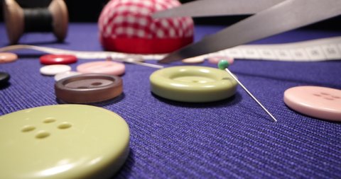Tailor's workshop with threads on spools and tape measure. Close up of a tailor's work desk with tailoring tools