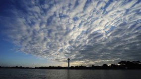 Beautiful cirrocumulus clouds pass on the sky above River. Time-lapse clip.