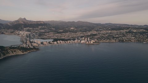 Aerial shot, drone point of view picturesque scenery of Penyal d'Ifac Natural Park and Calpe townscape view from above. Mediterranean Sea and town coastline at sunrise. Costa Blanca. Alicante. Spain