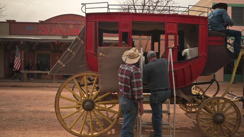 Tombstone , Arizona , United States - 12 22 2021: Tombstone Arizona, a guide is helping people into the stagecoach