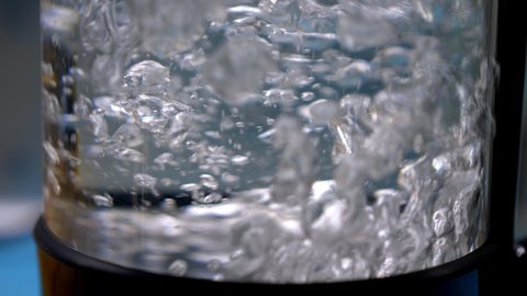 close up of boiling water in transparent clear glass electric kettle in slow motion. High quality 4k footage