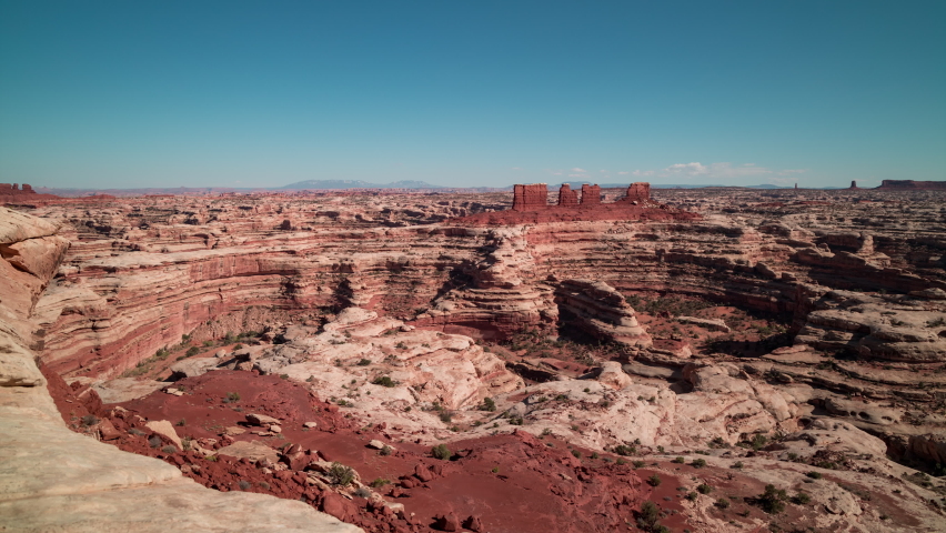 Short time-lapse from the Maze Overlook in the Maze District of Canyonlands National Park in, Utah. A few clouds are seen on the horizon in an otherwise clear sky. A labyrinth of canyons is visible. 