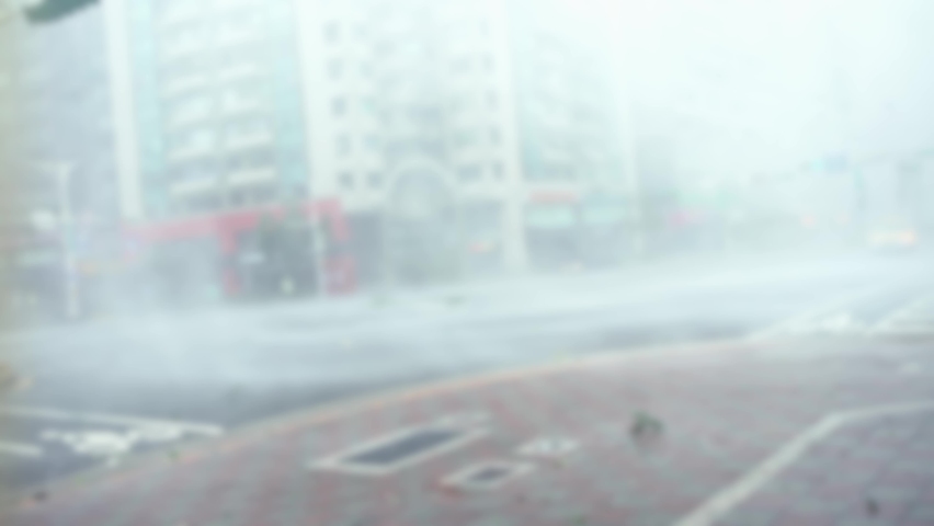 Blurred defocused Extreme Wind And Rain During A Super Typhoon Megi. A Street Taipei city with the strong hurricane winds. Car Traffic in asian road. Royalty-Free Stock Footage #1084835497