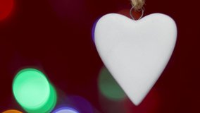 red paper heart in woman hand or ceramic white on rope against bokeh colorful light valentines day concept celebrate love 