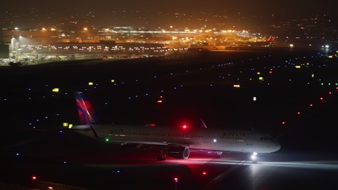 San Diego International Airport. 2021. Aircraft taking off the city airport as seen from the terminal. Scenic view of colorful illumination along the runway at night. High quality 4k footage