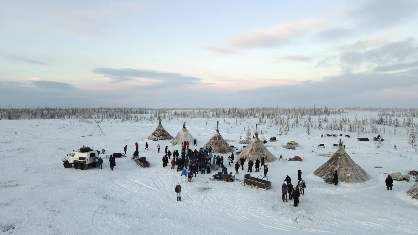 a crowd of people stands near the houses of northern residents