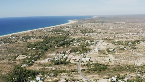 Slow motion aerial view of the neighborhoods of Todos Santos with houses and the island on a sunny day in a natural background Baja, Mexico	