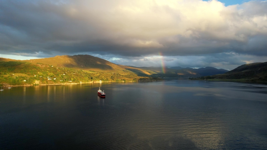 A super cool cinematic HD shot of the beautiful Loch Broom Ullapool while the sun going down over the Summer Isles in the far north west coast highlands of Scotland with a boat on the pleasant island.