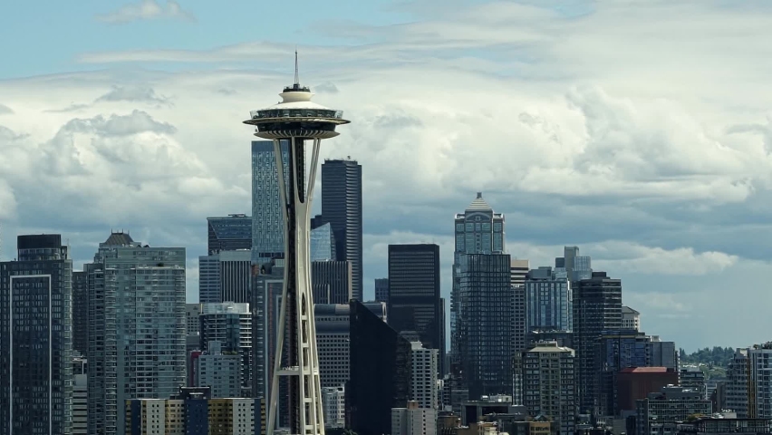 Close up slow motion shot of the famous Space Needle in Seattle Washington from Kerry Park with the large skyscraper skyline in the background on a sunny cloudy summer day.