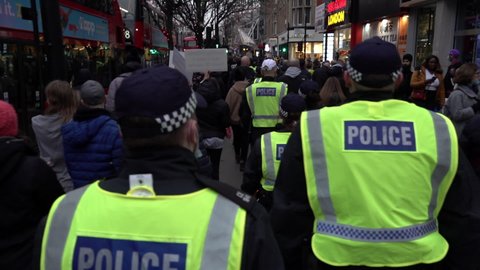 London , United Kingdom (UK) - 12 18 2021: A Slow Motion Shot Of Riot Police Marching Through A Crowded Street