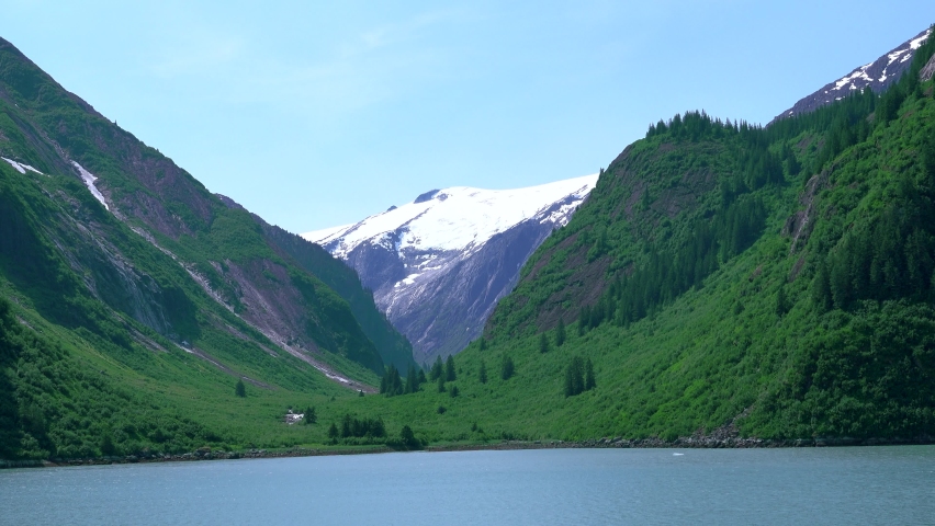 Cruise ship sailing in the fjord. The snow has melted in the mountains, Summer. The fjords of Alaska, unique natural landscapes. Alaska, USA. June 2019.